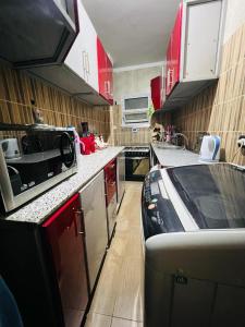 Una cocina con gabinetes rojos y un auto dentro. en Momen Pyramids Inn, en El Cairo
