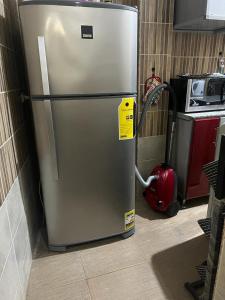 Un refrigerador de acero inoxidable con una etiqueta amarilla. en Momen Pyramids Inn, en El Cairo 29 fotos más