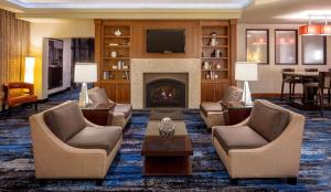 a lobby with a fireplace and chairs and a table at DoubleTree Suites by Hilton Minneapolis Downtown in Minneapolis