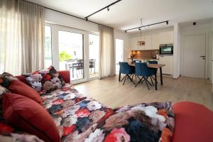 Apartments Kras 24 with Pool في سيجانا: غرفة معيشة مع أريكة حمراء ومطبخ