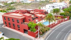 un edificio rojo al lado de una calle en Hotel Ecolife Tenerife, en San Miguel de Abona