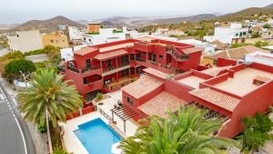 einen Luftblick auf ein rotes Haus mit einem Pool in der Unterkunft Hotel Ecolife Tenerife in San Miguel de Abona