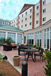 a group of tables and chairs in front of a building at Hilton Garden Inn West Monroe in West Monroe