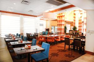 Hilton Garden Inn West Monroe في ويست مونرو: غرفة طعام مع طاولات وكراسي ومطعم
