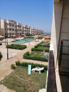 uitzicht op een zwembad vanaf een balkon van een gebouw bij قرية بلو لا جون شالية رقم 4012 غرفتين بالدور الأول علوي مدينة راس سدر محافظة جنوب سيناء in Ras Sedr