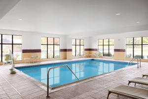 een zwembad met blauw water in een gebouw met ramen bij Hampton Inn & Suites West Haven in West Haven