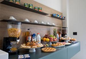 un buffet de nourriture sur un comptoir avec des assiettes de nourriture dans l'établissement Mars B&B, à Milazzo