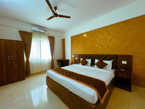 a bedroom with a large bed and a ceiling fan at Sai Bliss International, Bangalore in Bangalore