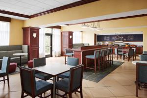 a restaurant with tables and chairs and a bar at Hampton Inn Indianapolis Northwest - Park 100 in Indianapolis