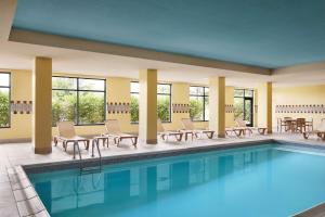 una piscina en un hotel con sillas y mesas en Hampton Inn Indianapolis Northwest - Park 100, en Indianápolis