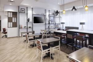 un restaurante con mesas y sillas y TV de pantalla plana en Hampton Inn & Suites Phoenix Downtown en Phoenix
