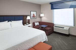 フェニックスにあるHampton Inn & Suites Phoenix Downtownのベッド1台、椅子、窓が備わる客室です。