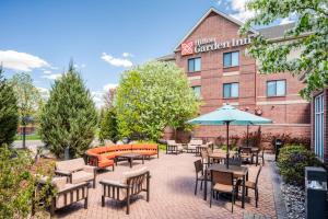 un patio con mesas y sillas frente a un hotel en Hilton Garden Inn Minneapolis Maple Grove, en Maple Grove