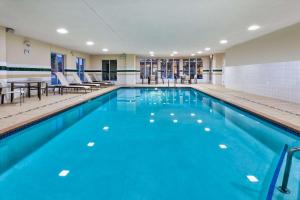 a swimming pool with blue water in a building at Hilton Garden Inn Minneapolis Maple Grove in Maple Grove