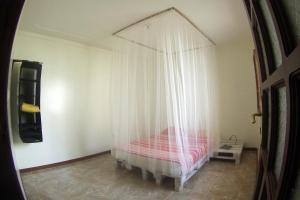 a bedroom with a bed with a mosquito net at Self-catering Apartment w/ Terrace in Tarrafal