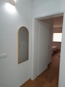 ein Spiegel an einer Wand neben einem Flur in der Unterkunft Apartmani Franciska in Jajce