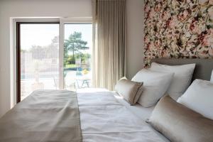 ein Schlafzimmer mit einem Bett und einem großen Fenster in der Unterkunft Apartments Kras 24 with Pool in Sežana