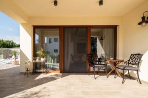 un patio con porte scorrevoli in vetro, tavolo e sedie di Apartments Kras 24 with Pool a Sežana
