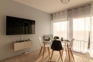 a dining room with a table and chairs and a flat screen tv at LeSaumurTranquille - Les VioIettes in Saumur