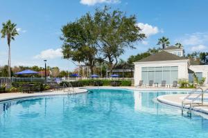 uma piscina com água azul num resort em Hilton Garden Inn Orlando at SeaWorld em Orlando