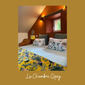 1 dormitorio con 1 cama con manta amarilla y verde en Le Lys Écossais, en Aubigny-sur-Nère