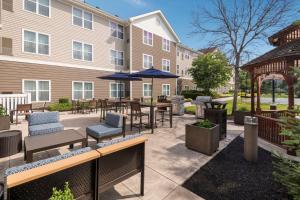 un patio con mesas y sombrillas frente a un edificio en Homewood Suites by Hilton Mount Laurel, en Mount Laurel