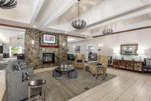 a living room with a fireplace and a stone wall at Homewood Suites by Hilton Mount Laurel in Mount Laurel