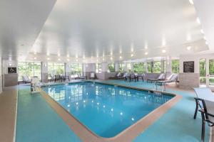 uma piscina num hotel com mesas e cadeiras em Homewood Suites by Hilton Mount Laurel em Mount Laurel