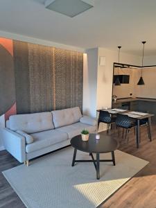 a living room with a couch and a table at Golden Apartments Świętej Barbary in Gdańsk