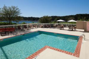 a swimming pool with tables and chairs on a resort at Hilton Garden Inn Savannah Airport in Savannah