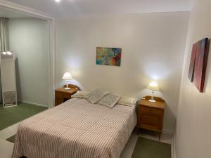 ein kleines Schlafzimmer mit einem Bett und zwei Nachttischen in der Unterkunft Departamento a metros de Peatonal in Mendoza