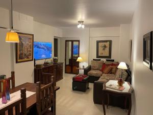 ein Wohnzimmer mit einem Sofa und einem Tisch in der Unterkunft Departamento a metros de Peatonal in Mendoza