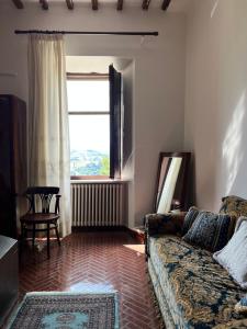 un soggiorno con divano e finestra di Castello ala Lucia a Monte Roberto
