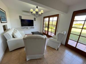 a living room with a couch and chairs and a tv at Jose Ignacio, La Juanita frente al mar in José Ignacio