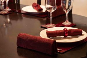 una mesa con un plato de comida y copas de vino en Lotus Heritage Homagama, en Homagama