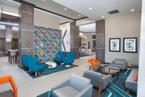 um átrio com cadeiras azuis e uma prateleira para vinhos em Hampton Inn & Suites LAX El Segundo em El Segundo