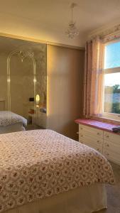 1 dormitorio con cama, ventana y espejo en Idyllic Countryside Retreat in Durham County near Sedgefield en Trimdon Grange
