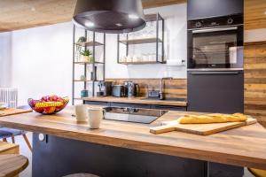 a kitchen with a counter with a cutting board at Loft Monte Clusio - OVO Network in La Clusaz