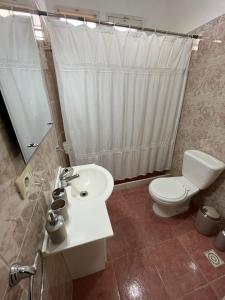 a bathroom with a white toilet and a sink at Jose Ignacio, La Juanita frente al mar in José Ignacio