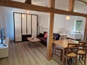 a living room with a couch and a table at Apartment auf dem Hof einer historischen Mühle in Holzhausen +7 photos