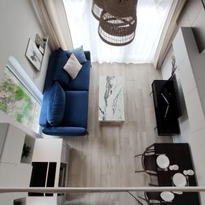 a living room with a blue chair and a table at Morze Wyspa in Gdańsk