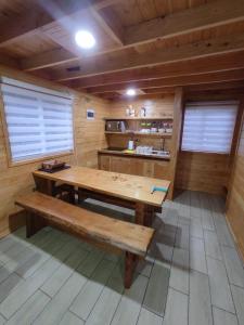 Habitación con mesa de madera y banco. en Cabaña Los Alerces, en Licán Ray