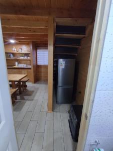 a kitchen with a refrigerator and a table in a cabin at Cabaña Los Alerces in Licán Ray