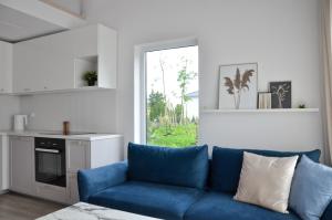 a living room with a blue couch and a kitchen at Morze Wyspa in Gdańsk