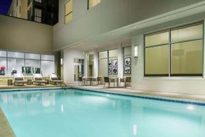 a large swimming pool in a building with chairs at Hilton Garden Inn Sunnyvale in Sunnyvale