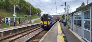 een blauwe en gele trein die een treinstation aandoet bij Musselburgh / Edinburgh near QM Uni (30) in Fisherrow