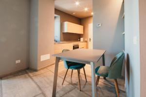 una pequeña cocina con mesa y 2 sillas en Appartamento Meda - Lakeside Leisure & Business, en Cissano