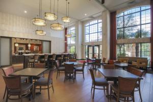 una sala da pranzo con tavoli, sedie e finestre di Hampton Inn & Suites Camarillo a Camarillo
