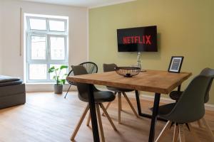 sala de estar con mesa de madera y sillas en Studio THREE / Wifi / Netflix / 3 getrennte Betten en Chemnitz
