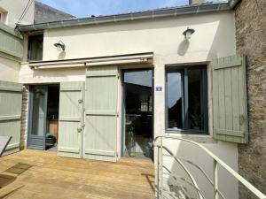 een huis met groene deuren en een patio bij Gîte de la petite charriere in Santenay